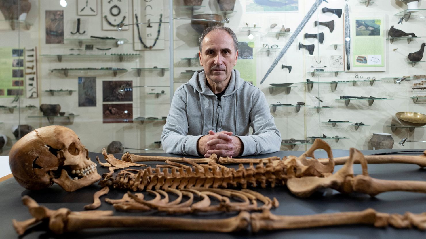 Archaeologist Dariusz Polinski poses with the remains of a woman found at the 17th-century cemetery for rejected people.