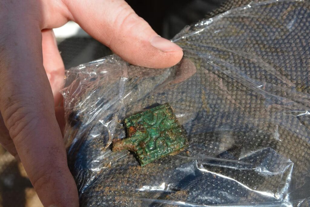 One of the rosette-patterned bronze ornaments that decorated a belt found at the grave site