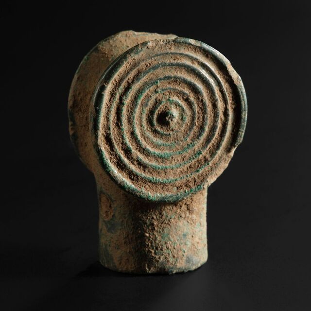 A socketed bronze artifact, its purpose shrouded in the mysteries of ancient craftsmanship.