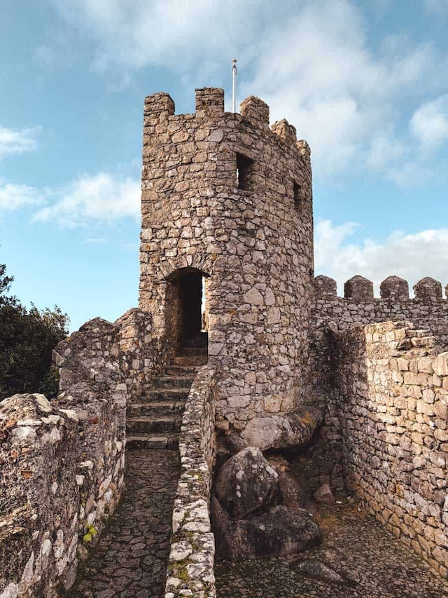 Tread the ancient stone steps of Moors Castle, nestled in Portugal’s Sintra Mountains, where nature and history blend seamlessly as you ascend to the castle walls