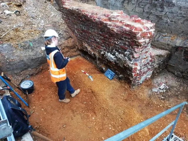 An Archaeologist Carefully Records Post-Medieval Walls Built Above Layers of Saxon Settlement.