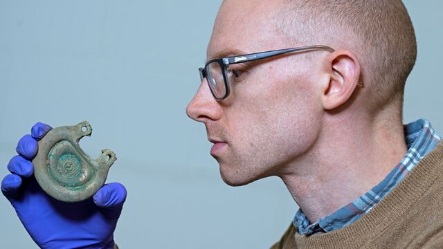 Dr. Matthew Knight, curator, carefully examining a bronze artifact from the extraordinary Peebles Hoard.