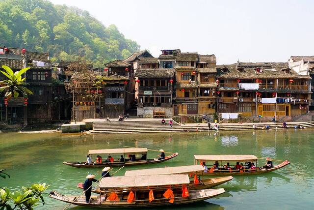 Nestled along the Tuo River, the village is famous for its wooden stilt houses that seem to float above the water.