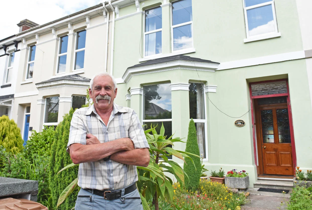 Colin Steer, a 70-year-old man, stands in front of his house in Plymouth, UK.