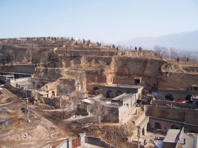 A village with multiple cave homes nestled into the hillsides of the Loess Plateau in northern China