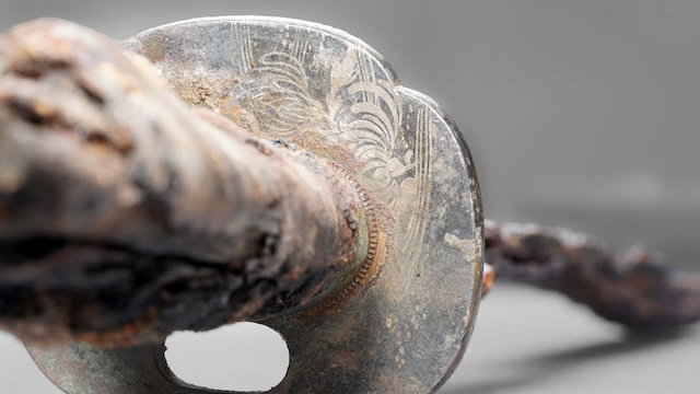  A close-up of the wakizashi’s ornate handguard (tsuba), showcasing intricate engravings, including the chrysanthemum motif from the Edo period