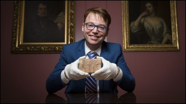 A closer look at Dr. Mansfield holding the Babylonian clay tablet, whose mathematical codes date back to 1800 BCE