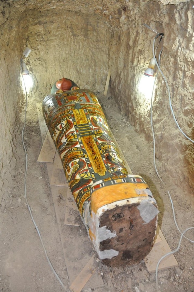 The vividly painted sarcophagus lies in its tomb, preserved for centuries beneath the sands of Luxor, showcasing ancient Egyptian artistry and religious symbolism