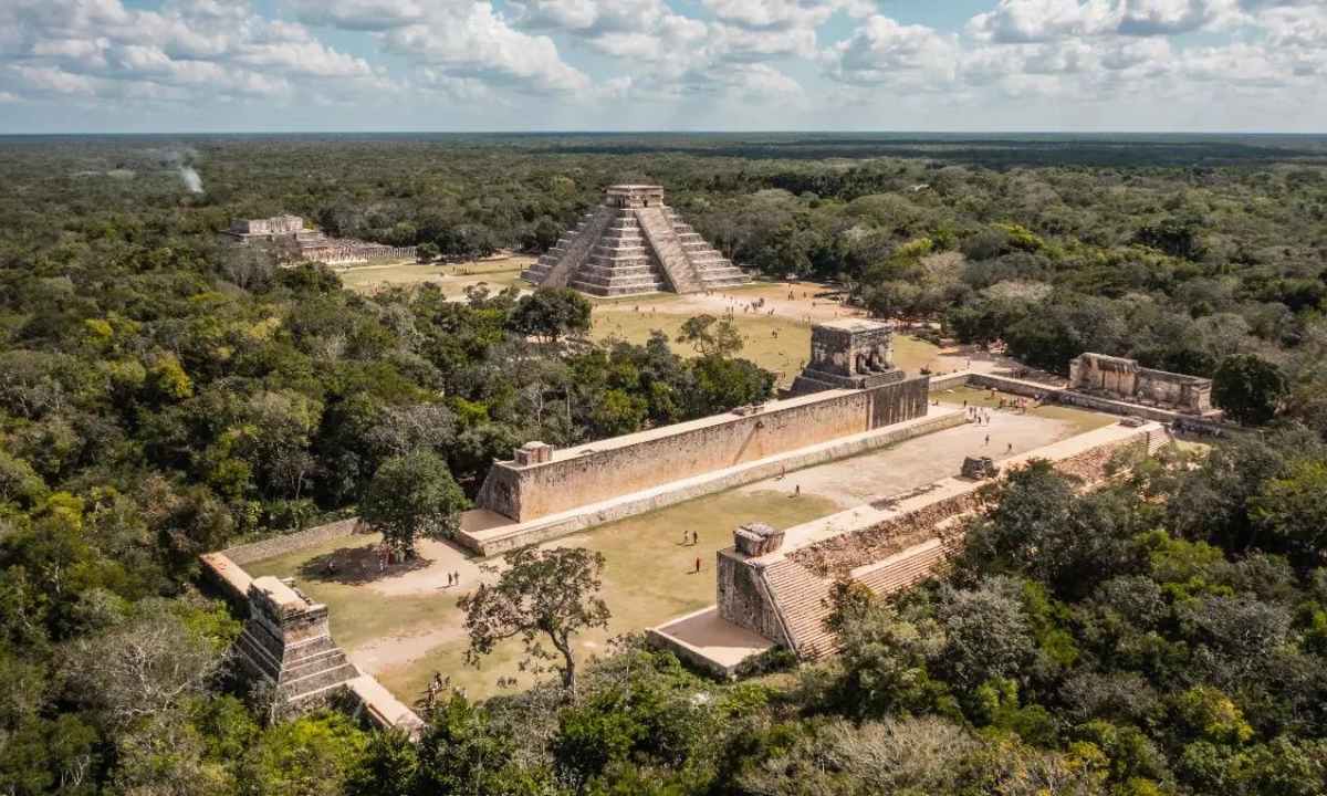 A breathtaking aerial view of the ancient city of Chichen Itza, with the Kukulcan Temple standing as its centerpiece amidst the Yucatan jungle