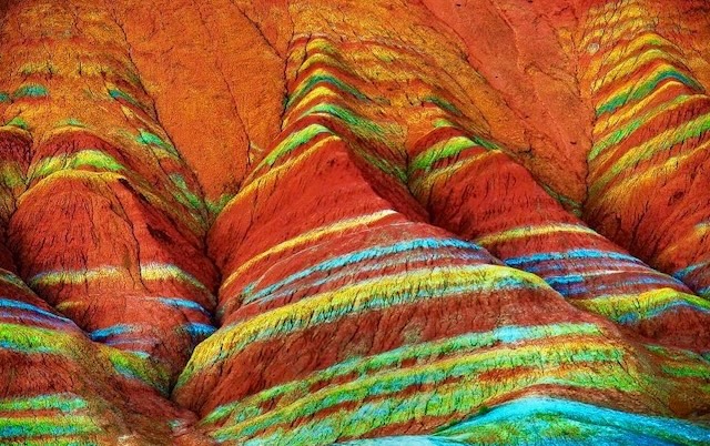 The mountains of Zhangye Danxia reveal their geological complexity with layers of red, yellow, and green bands, formed over millions of years through the deposition of various minerals