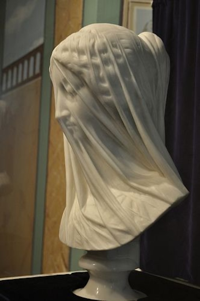 From this angle, you can appreciate how the artist, Giovanni Strazza, used his skill to create the illusion of a real veil draping over the statue