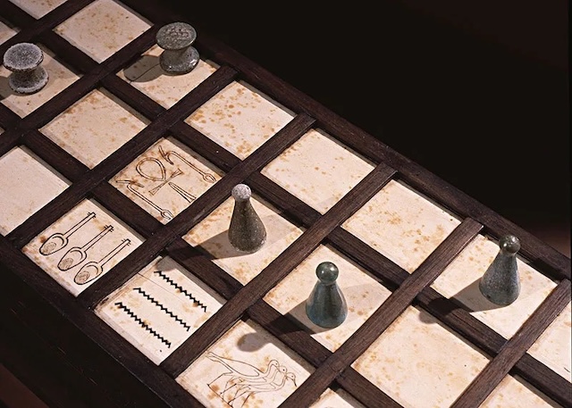 A detailed view of a Senet game board showcasing the carved squares and playing pieces, used by ancient Egyptians to navigate their path toward the afterlife