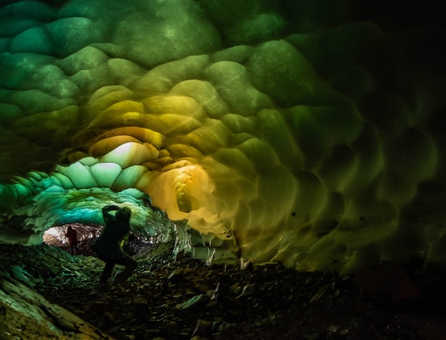 The rich shades of teal and green create a magical scene inside the ice caves, as the walls of frozen water seem to pulse with light and life