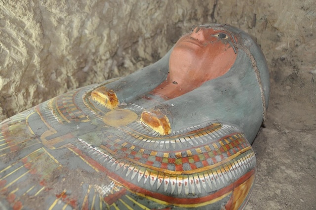 A detailed look at the intricate face and chest carvings on the sarcophagus, showcasing ancient Egyptian craftsmanship