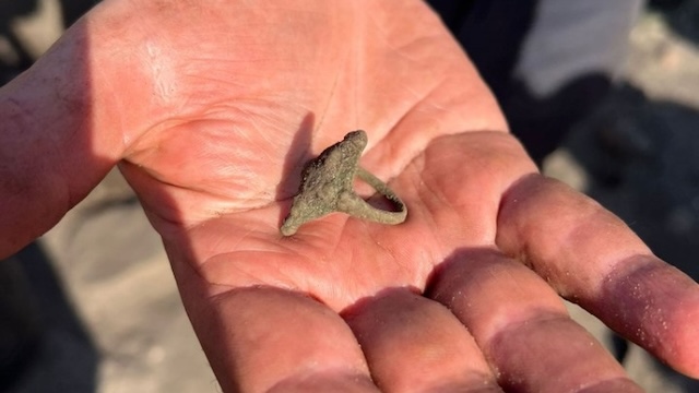 The ancient Pictish ring carefully cradled in the hands of its discoverer, showcasing its unique craftsmanship and historical significance