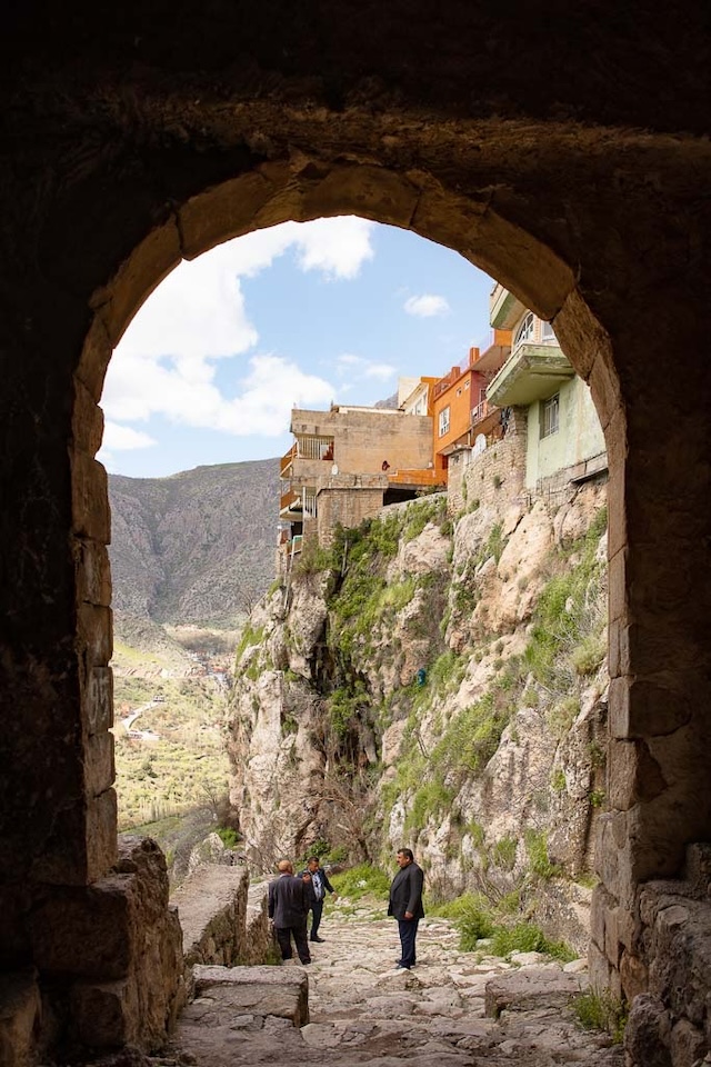 A view through an old stone archway in Amadiyah, revealing the stunning cliffside dwellings of this ancient city