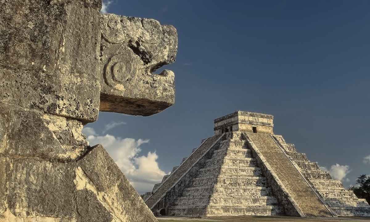 A striking view of the Kukulcan Temple, framed by the stone-carved serpent that seems to guard the entrance to this ancient wonder