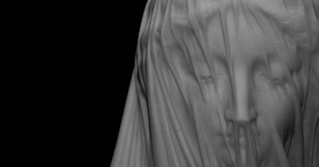 The face of the Veiled Virgin, softly hidden beneath a marble veil, symbolizes purity, faith, and divine beauty