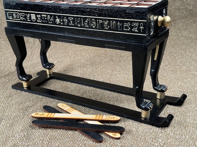 A replica of the Senet game board with its original throwing sticks, which players used to determine their moves in the game, dating back over 2,000 years