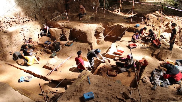 Archaeologists at work in the Nenggiri Valley, meticulously excavating the site to uncover artifacts and skeletons that have been hidden for thousands of years