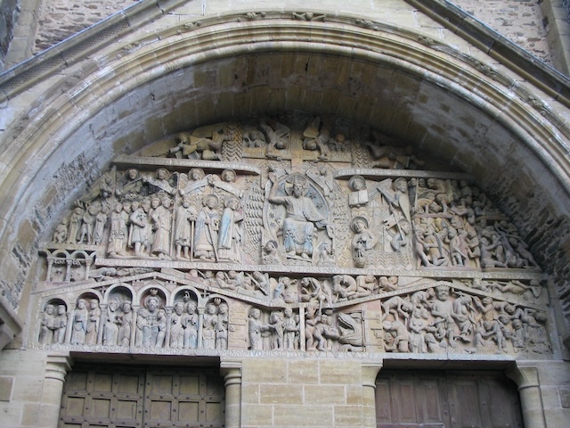 The intricate façade of the Abbey of Sainte Foy, where "The Peeker" can be found among the numerous carvings, adding a touch of levity to the otherwise solemn religious imagery