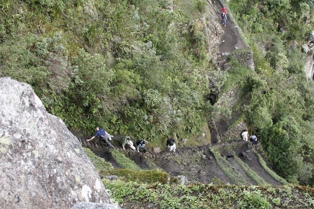 Hikers make their way up the perilous path of Huayna Picchu, showcasing the demanding yet rewarding ascent