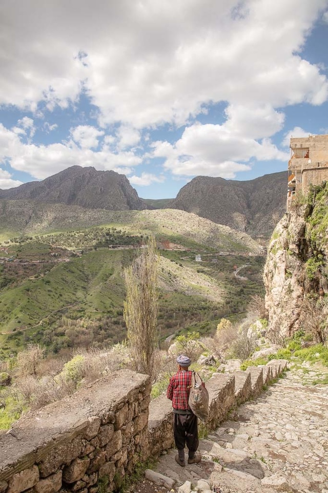 A resident of Amadiyah walks down the old stone steps, overlooking the scenic valleys that surround this mountaintop city