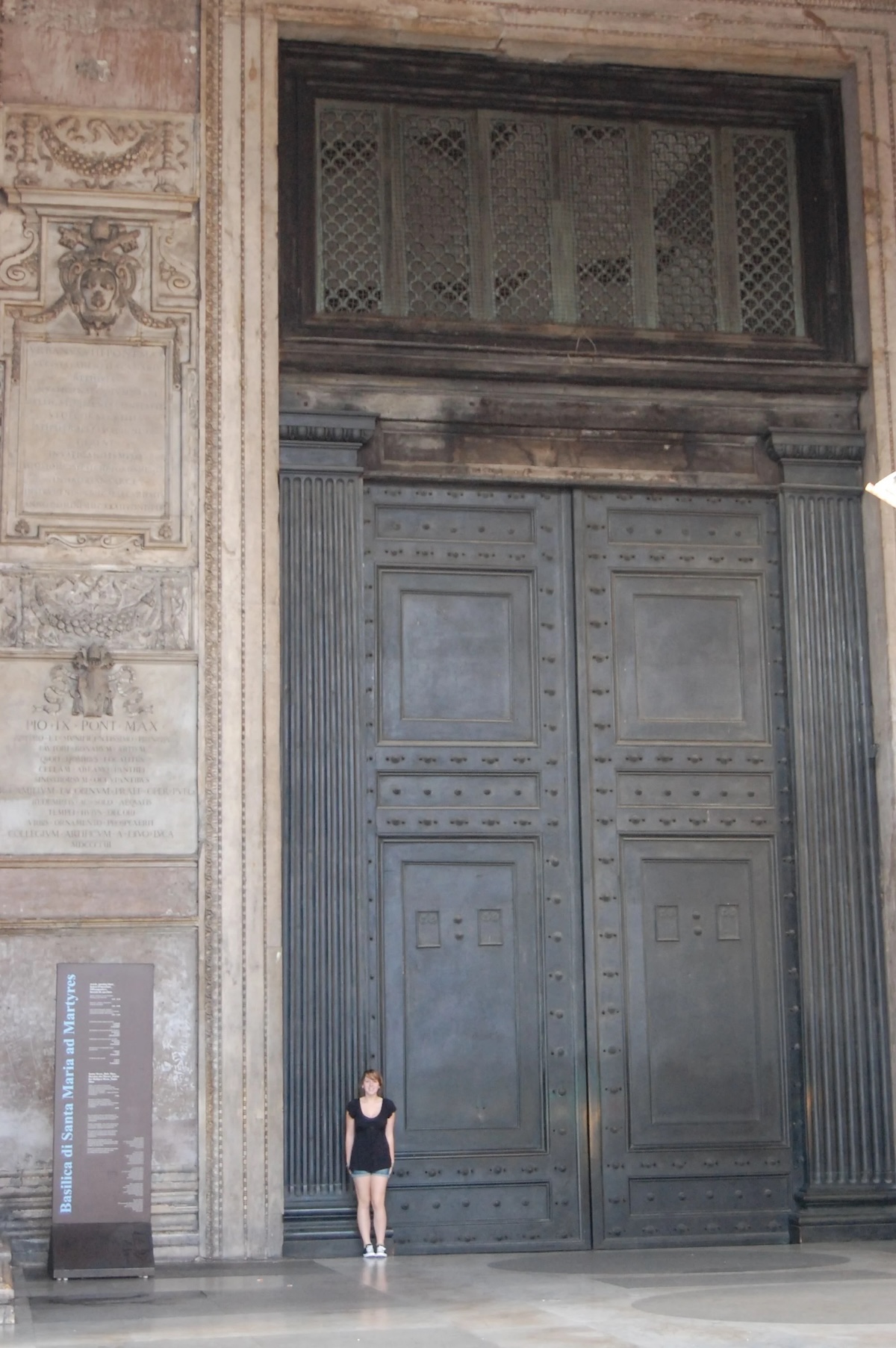 A visitor stands beside the Pantheon’s towering bronze doors, offering a sense of the monumental scale of this ancient Roman marvel