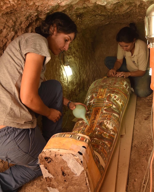 Archaeologists carefully document and restore the sarcophagus in the small tomb where it was unearthed