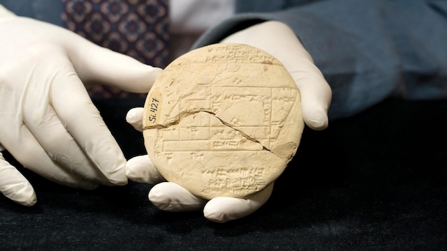 A detailed view of the circular Babylonian clay tablet, showing the intricate engravings that ancient mathematicians used to solve practical problems