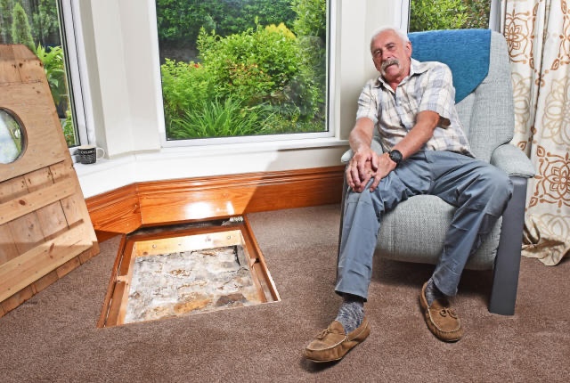 Colin Steer sits proudly next to the well that has transformed his home into a unique historical attraction