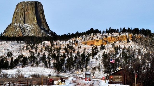 The snow-covered landscape surrounding Devils Tower, showcasing the monument’s beauty through the changing seasons