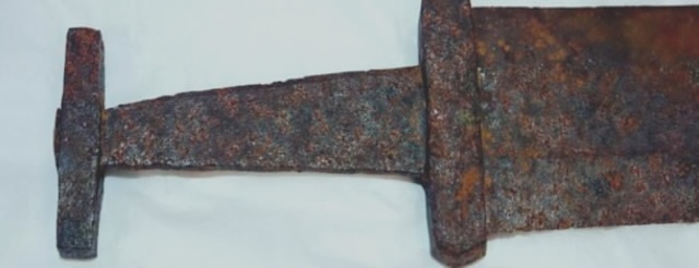 The rust-covered hilt of the Viking sword, revealing the craftsmanship of the ancient weapon, even after centuries of exposure to the elements