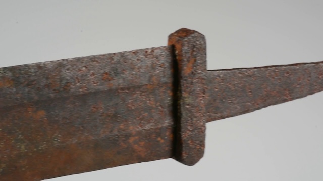 A close-up of the sword’s hilt, highlighting the detailed craftsmanship and design typical of Viking weapons from the 10th century