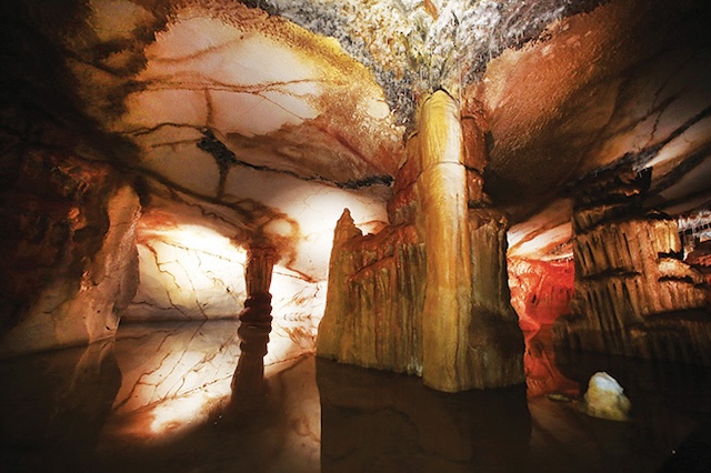 The captivating interior of the Cosquer Cave, featuring stalactites and an array of prehistoric paintings