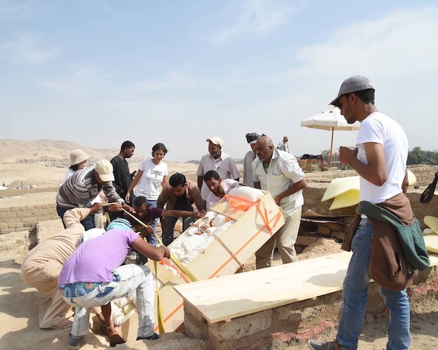 Archaeologists carefully lift a 2,800-year-old sarcophagus, revealing the preserved secrets of an ancient court advisor