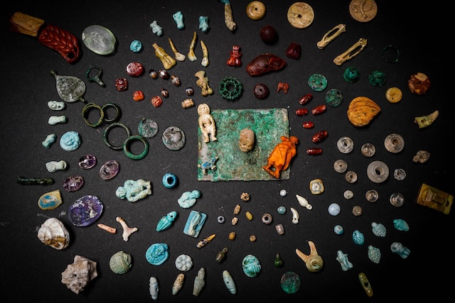 A collection of charms and figurines discovered in a box in Pompeii, possibly used for mystical or protective purposes in the ancient city.