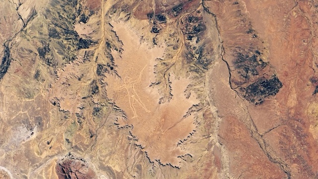 Satellite image highlighting the vast expanse of the Marree Man geoglyph, visible even from space, surrounded by the rugged terrain of the Australian desert