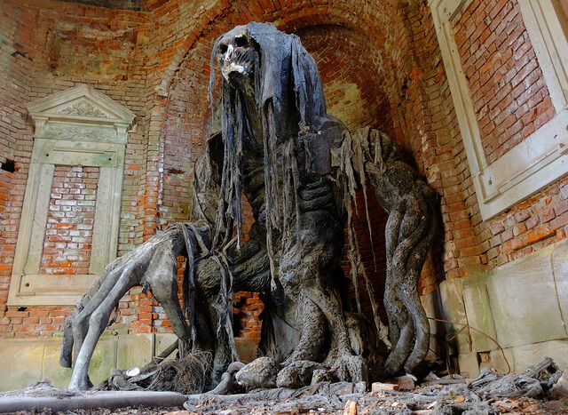 Another angle of the grotesque figure, surrounded by the cracked and crumbling mausoleum walls.