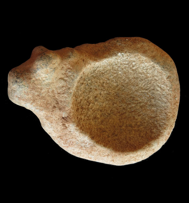 A beautifully carved stone palette featuring a zoomorphic bovine design, recovered from the communal cemetery of Lothagam North, Kenya, highlighting the symbolic connection between people and animals in ancient times.