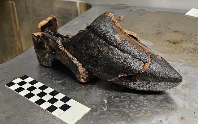 A well-preserved 15th-century wooden clog with a double heel, made from birch wood, unearthed in a Dutch cesspit in Alkmaar. The unique design indicates it may have belonged to an urban resident rather than a rural farmer.