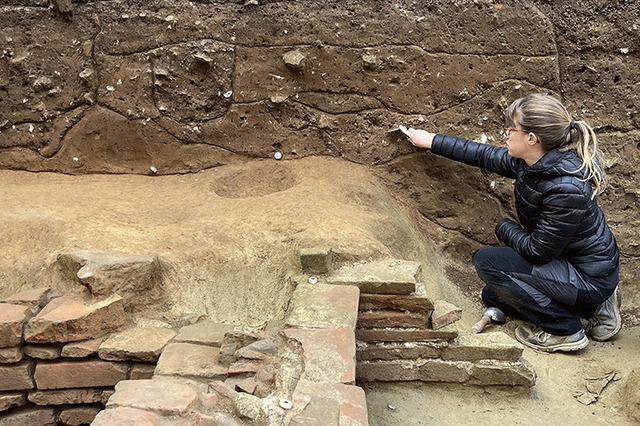 A member delicately mapping the stratigraphy of the site, identifying layers of historical significance.