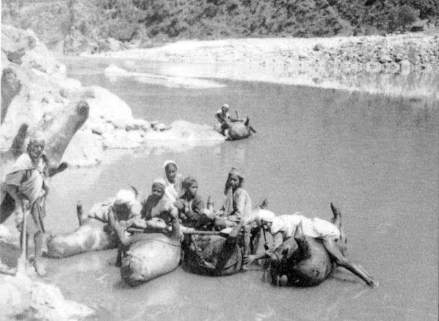 A closer look at the innovative transportation method—villagers crossing the river on makeshift skin rafts.