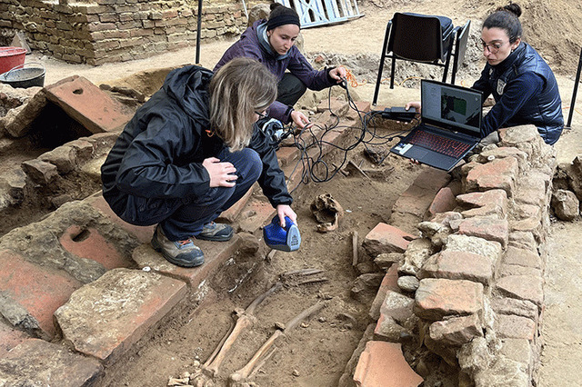 A collaborative team of researchers conducting detailed 3D photogrammetry and analysis of skeletal remains at the excavation site.