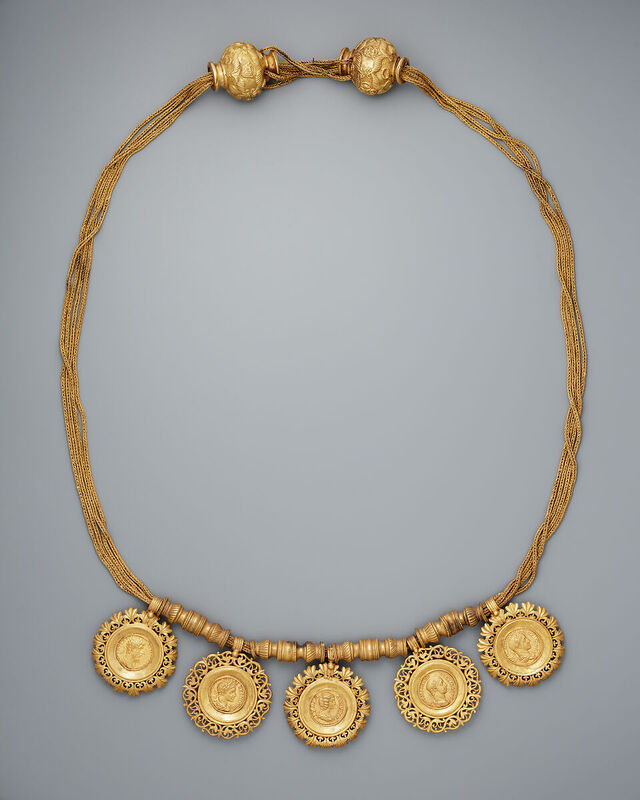 A collar featuring medallions embedded with coins of Roman emperors highlights the cross-cultural exchanges and enduring allure of gold.