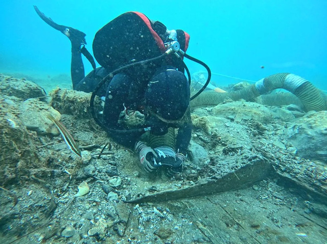 A diver carefully examines remnants of the 6th-century BCE shipwreck off Santa Maria del Focallo, Sicily, during the underwater excavation.