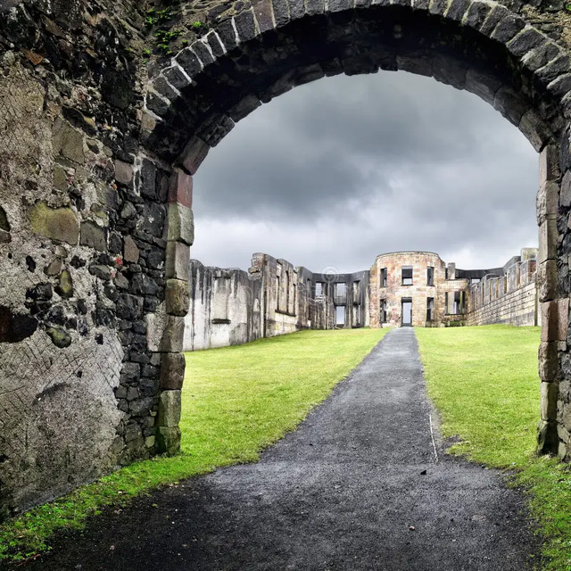 A dramatic arched pathway leading into the heart of the Downhill House ruins, offering a glimpse into its grand past.