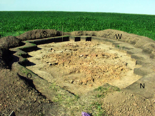 A photograph from 2004 captures the excavation process of House 6, revealing its archaeological significance.