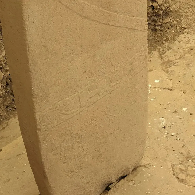 A stone pillar at Gobekli Tepe intricately carved with patterns, showcasing the artistic skill and spiritual significance of ancient people.