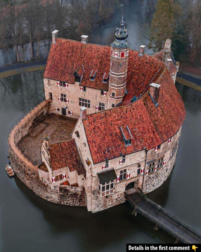 Aerial view of Vischering Castle, showcasing its iconic red-roofed design surrounded by a tranquil moat.